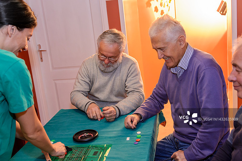 一群退休人员正在家中玩轮盘赌。图片素材