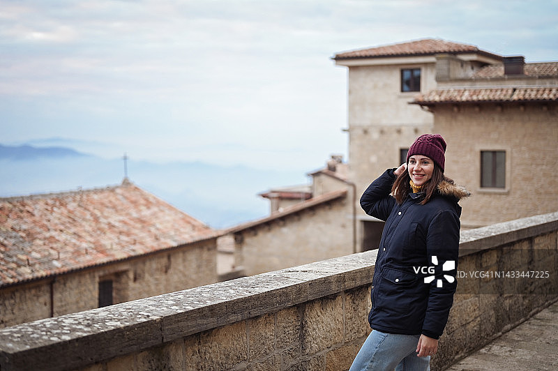 年轻的女旅行者在意大利冬季的城市风景中欣赏美丽的景色。图片素材