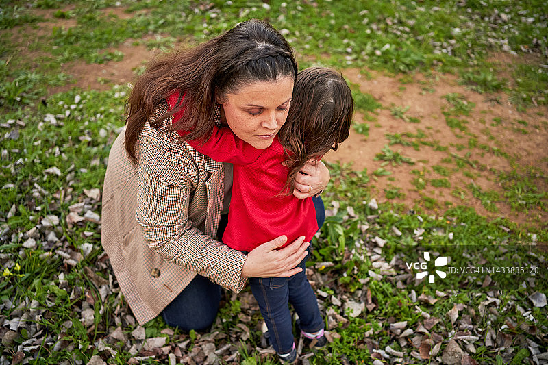 在公园外面，一位妇女抱着她的小女儿。图片素材