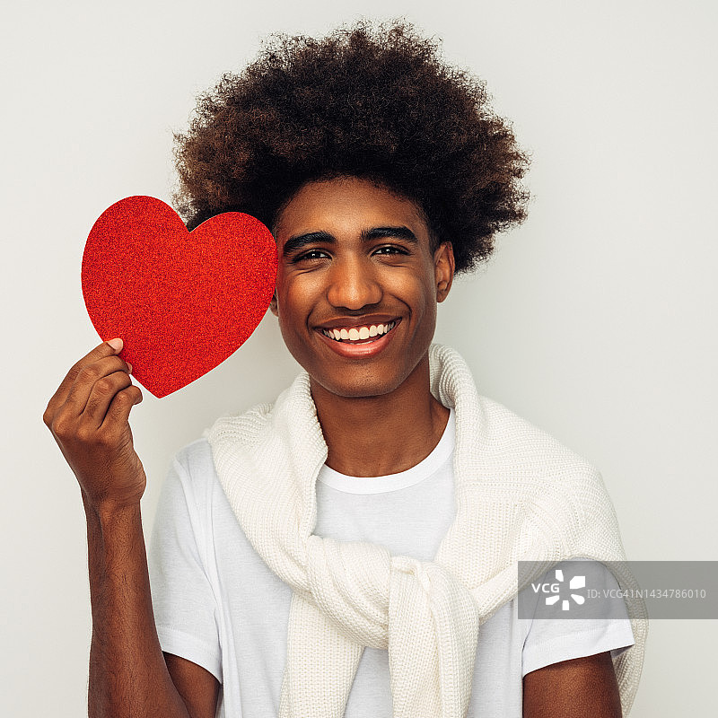 情绪化的非洲裔美国人，非洲发型，拿着人造心脏图片素材