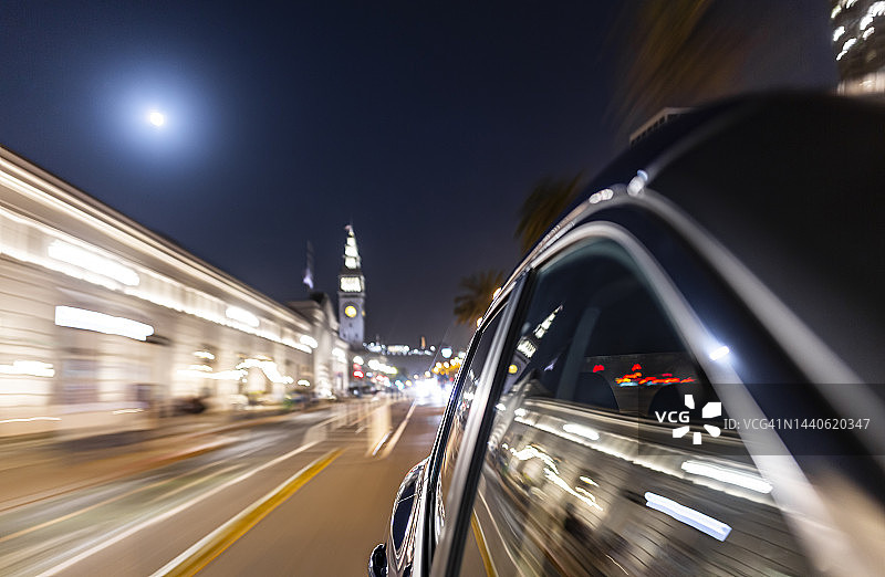 夜晚，汽车行驶在旧金山的Embarcadero街和渡轮大厦旁。图片素材