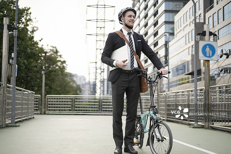 在城市里有自行车的中年成年商人图片素材