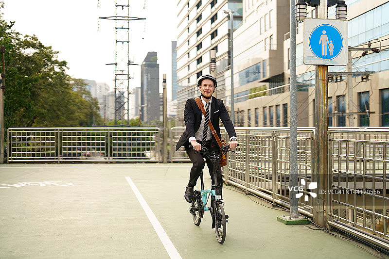 在城市街道上骑自行车上班的商人图片素材