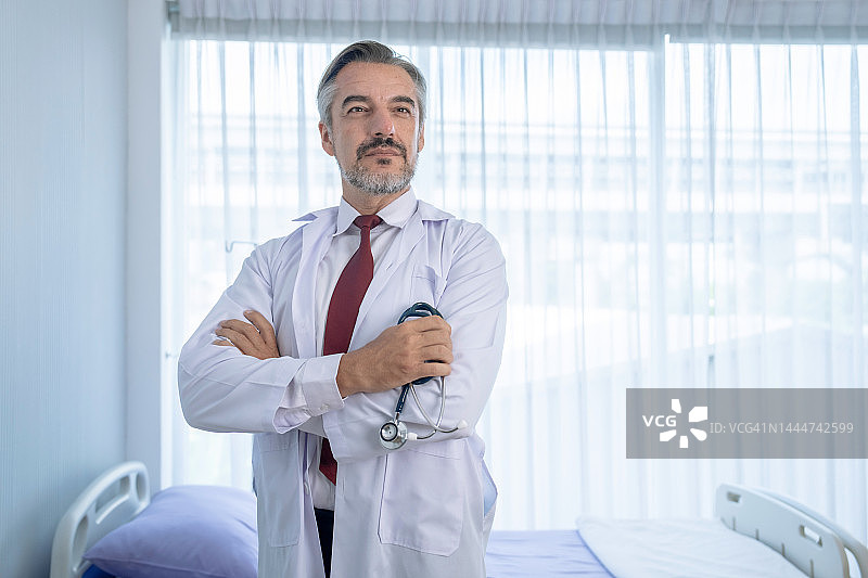 自信的白大褂白人男性医生站在医院的肖像。图片素材