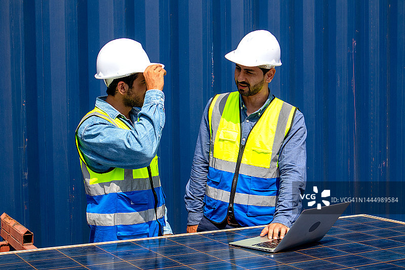 两名工程师团队讨论在工作场所使用光伏太阳能电池板的方案，可持续发展理念图片素材