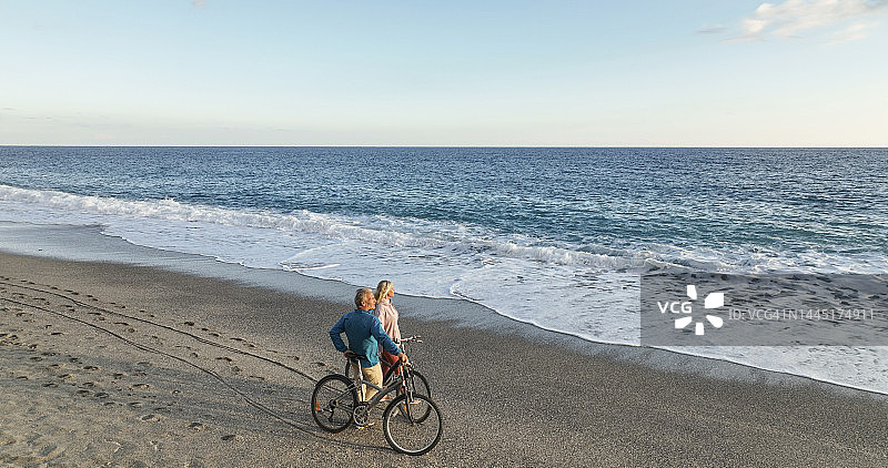 海滩上骑自行车的成熟夫妇的鸟瞰图图片素材