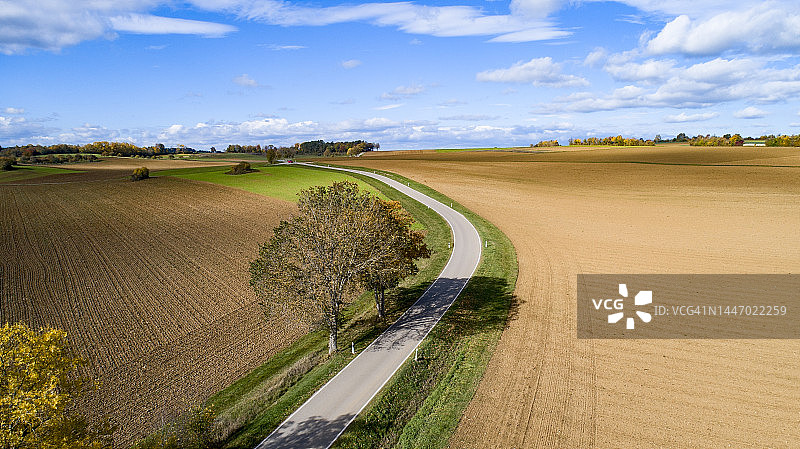 蜿蜒的乡间小路从上方穿过农田图片素材