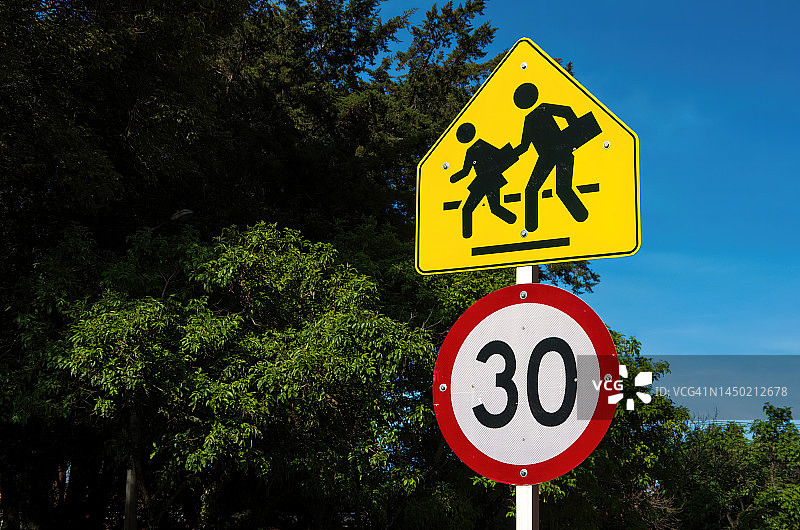 学校儿童过马路交通警告标志和时速30公里限速标志图片素材