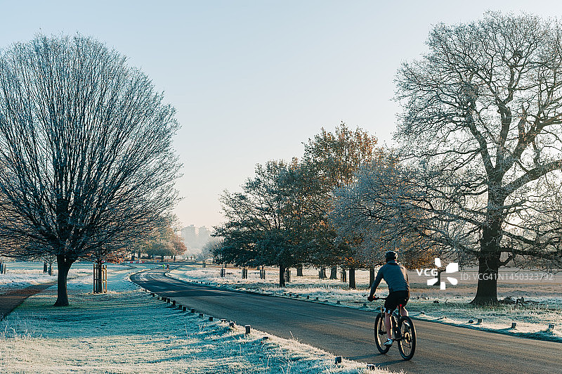 在寒冷的伦敦公园里，一个面目全非的自行车手图片素材