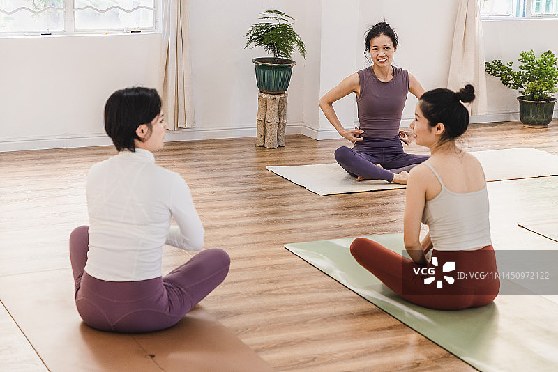 一群亚洲女性在瑜伽训练后坐在一起聊天图片素材