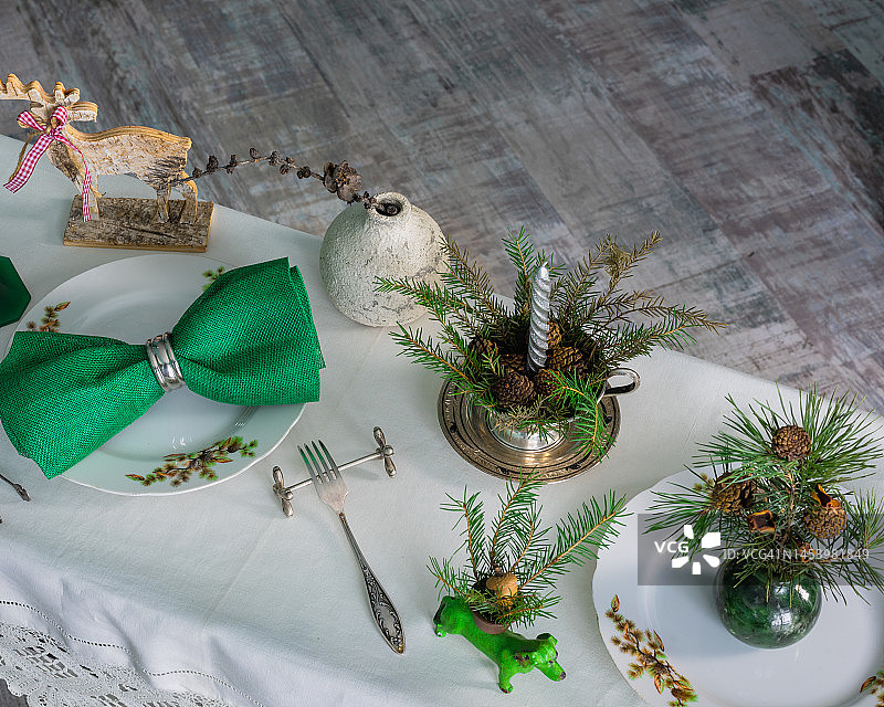 新年的餐桌布置有亚麻桌布，蜡烛和云杉树枝图片素材