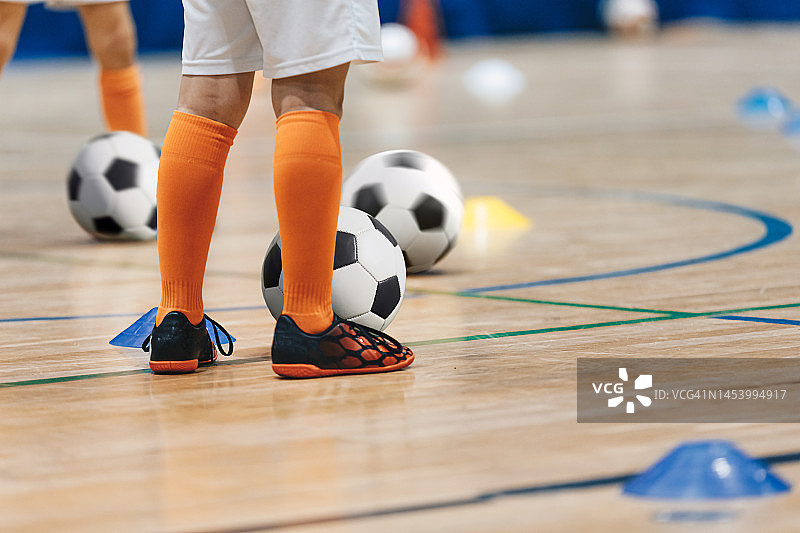 儿童足球冬季训练。学童足球练习班。足球男孩的腿和球图片素材