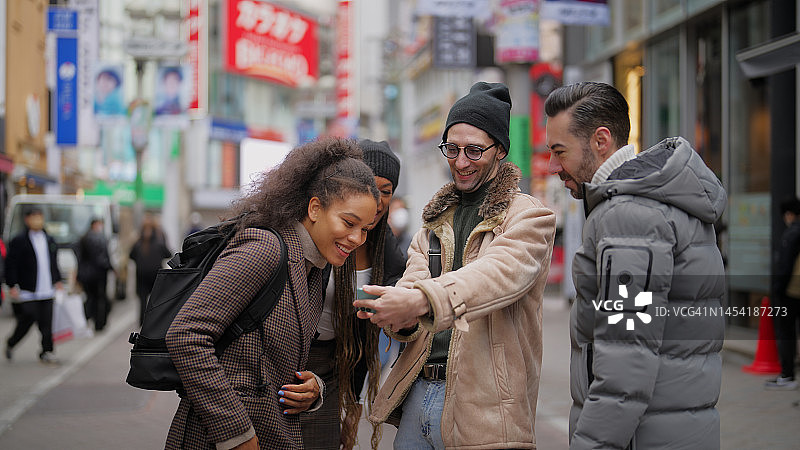 游客们用手机探索东京涩谷的小镇图片素材