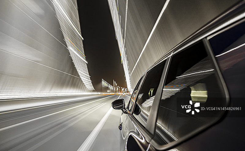 夜间，一辆电动汽车行驶在旧金山未来的海湾大桥上。图片素材