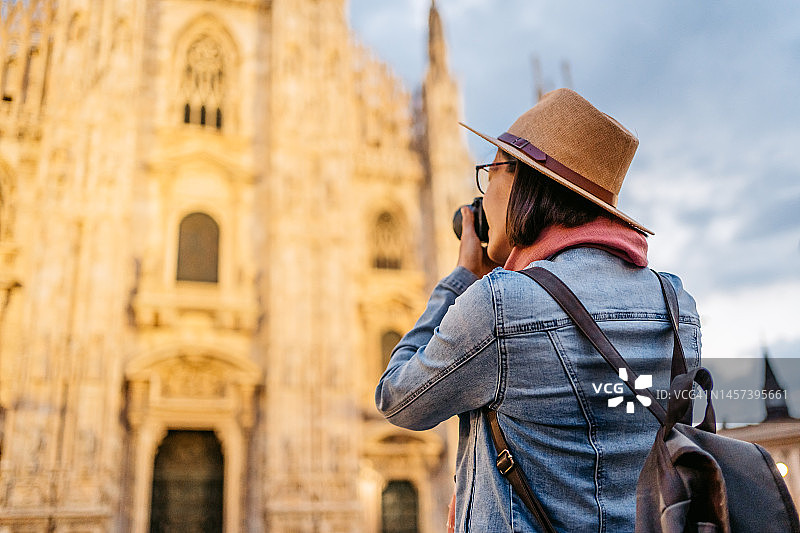 年轻的女游客在米兰大教堂拍照图片素材