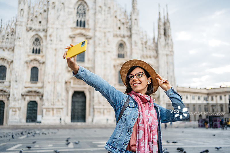 年轻的女游客在米兰大教堂前自拍图片素材