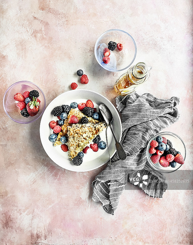 燕麦条，牛奶和浆果放在碗里，粉红色的背景图片素材