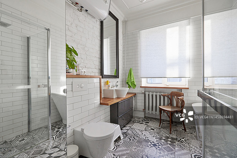 浴室内部为白色，带有镜子脸盆、马桶、浴缸和带窗户的淋浴间图片素材