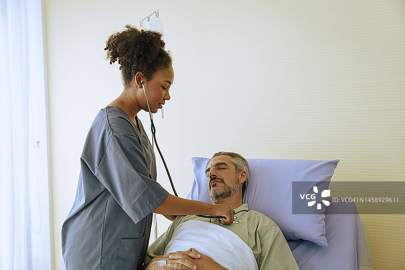 医生在体检室内用听诊器给病人脉搏，是医疗保健和医药行业的理念。图片素材