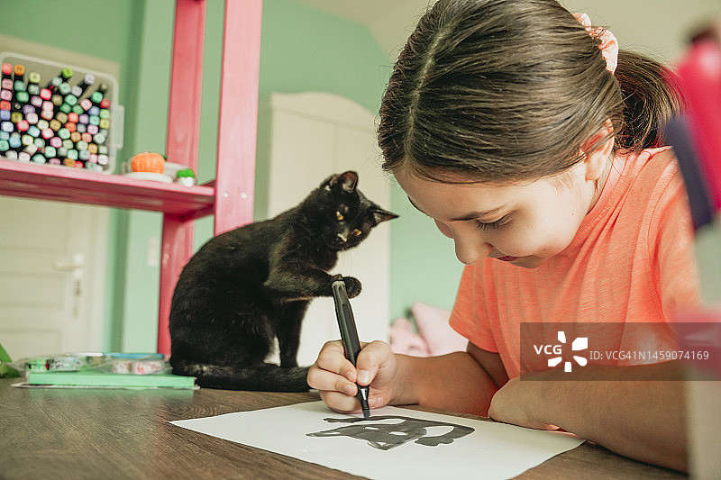 女孩在家在纸上画猫图片素材
