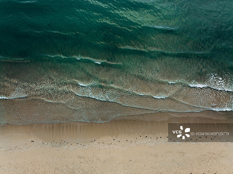 海浪拍击沙滩的鸟瞰图图片素材