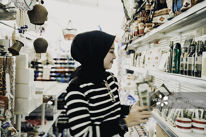 年轻的穆斯林妇女正在购买传统的土耳其纪念品图片素材