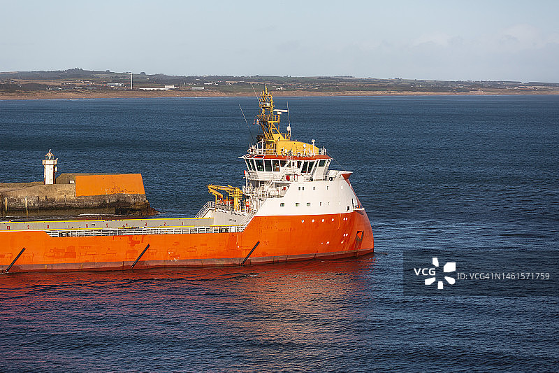 石油钻井平台支援船离开港口，阿伯丁，苏格兰。图片素材