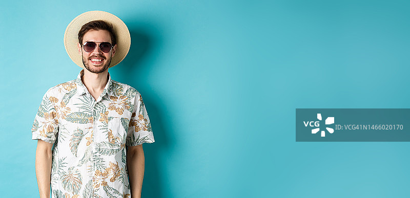 帅气的微笑的家伙太阳镜和夏天的衬衫，享受假期图片素材