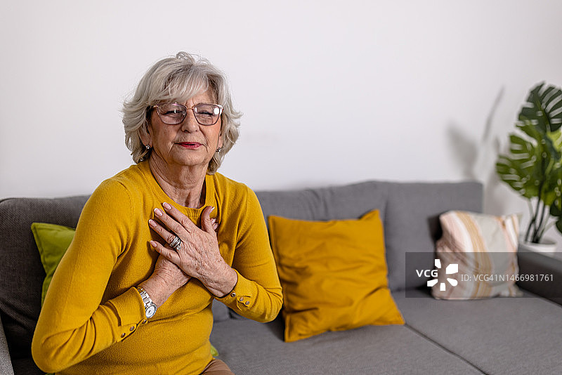 一位孤独的老年妇女患有慢性呼吸和心脏问题，在与胸部难以忍受的疼痛作斗争的同时，她感到绝望。图片素材