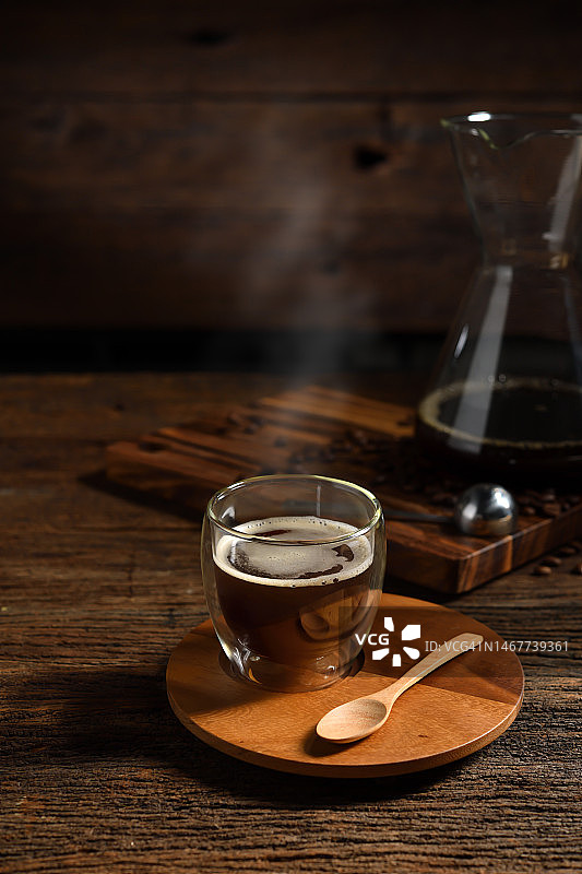 一杯滴漏咖啡与烟和咖啡豆在旧的木制背景图片素材
