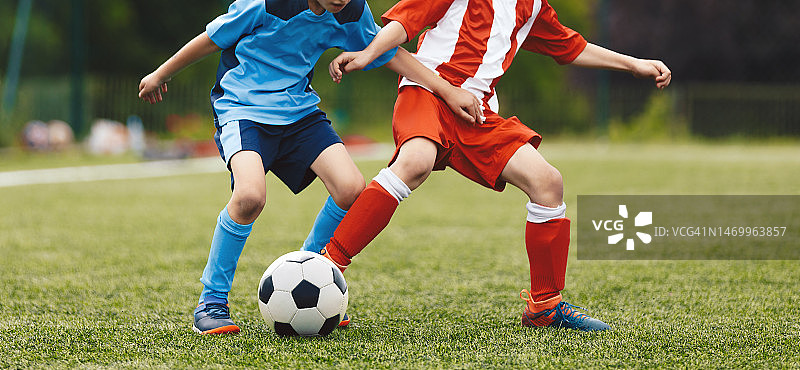 孩子们做运动。在一场足球比赛中，足球队的孩子们在争球。红蓝足球队的学生图片素材