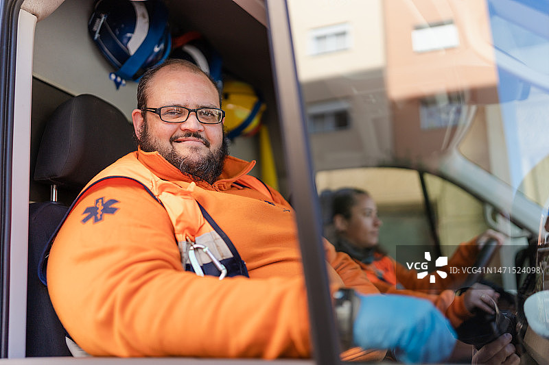 肖像的快乐和微笑的护理人员通过救护车的窗口。图片素材