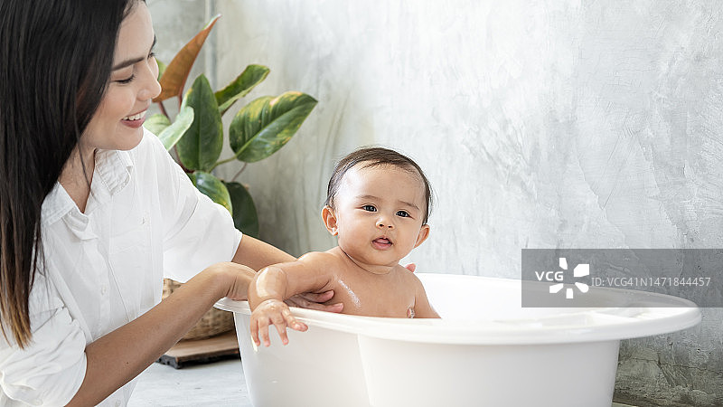可爱的女婴洗澡与母亲，家庭，孩子，童年和为人父母的概念图片素材