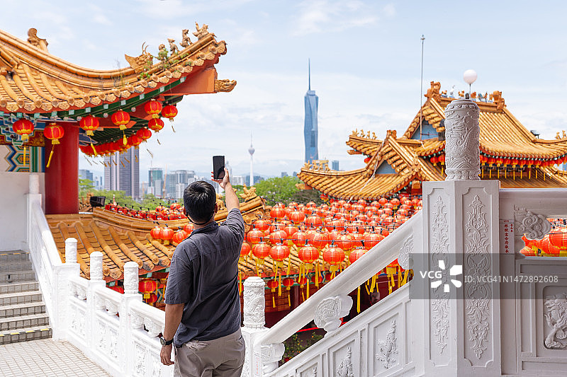 一名游客用智能手机在吉隆坡的天后寺拍照图片素材