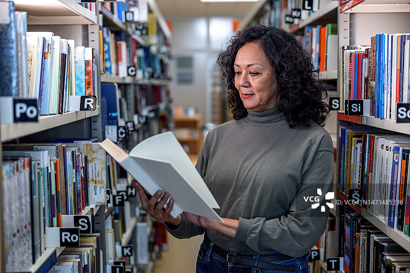 一位拉丁美洲女性在图书馆看书图片素材