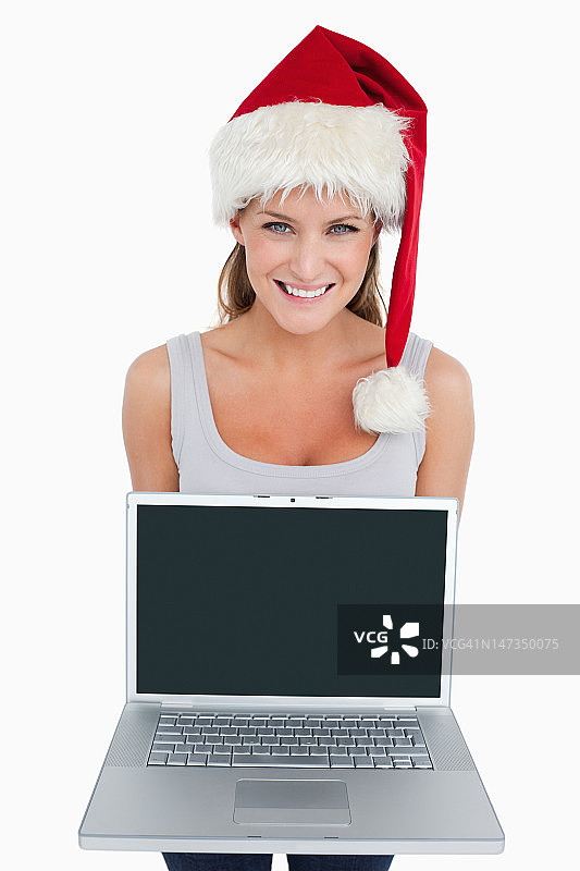 戴着圣诞帽的女人展示笔记本图片素材