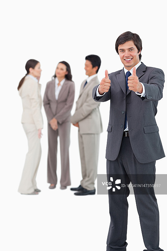 推销员对站在他身后的同事们竖起大拇指图片素材
