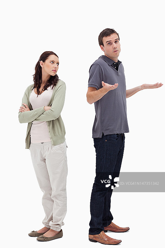 男人和愤怒的女人背靠背站着图片素材