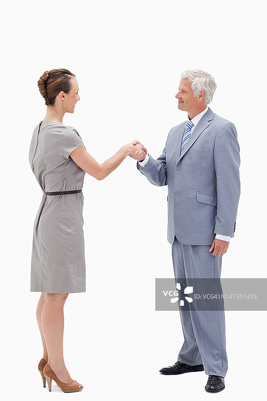 白发商人面带微笑，与女子握手图片素材