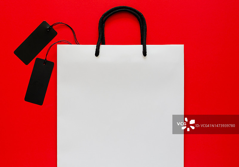 白色购物袋，黑色价格标签，红色背景黑色星期五的概念图片素材