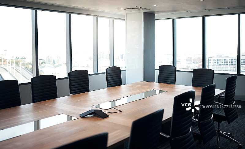 空的会议室和商务大楼，有椅子和一张桌子，供公司的车间使用。会议空间，室内或工作场所，配有新家具和窗户，用于模拟公司办公室图片素材