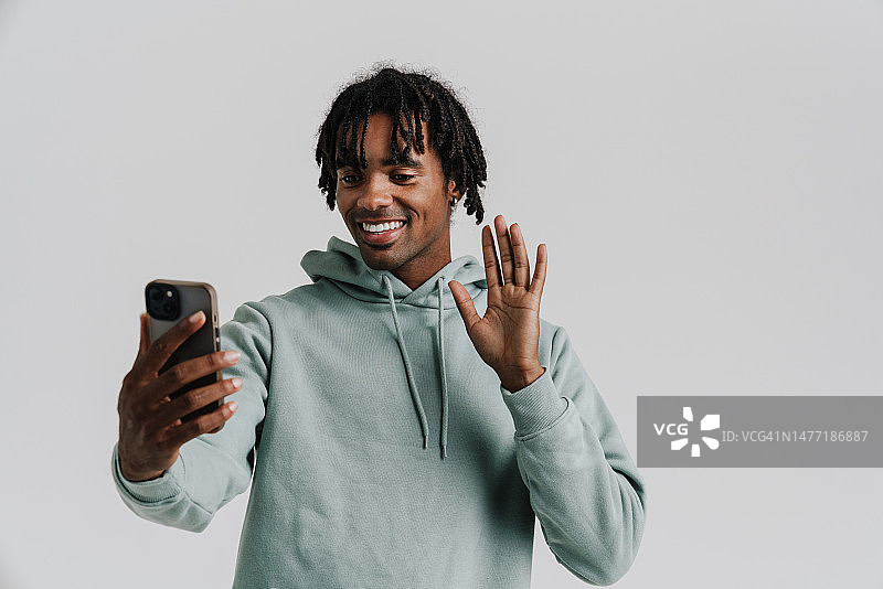 黑人青年在用手机自拍时打手势图片素材