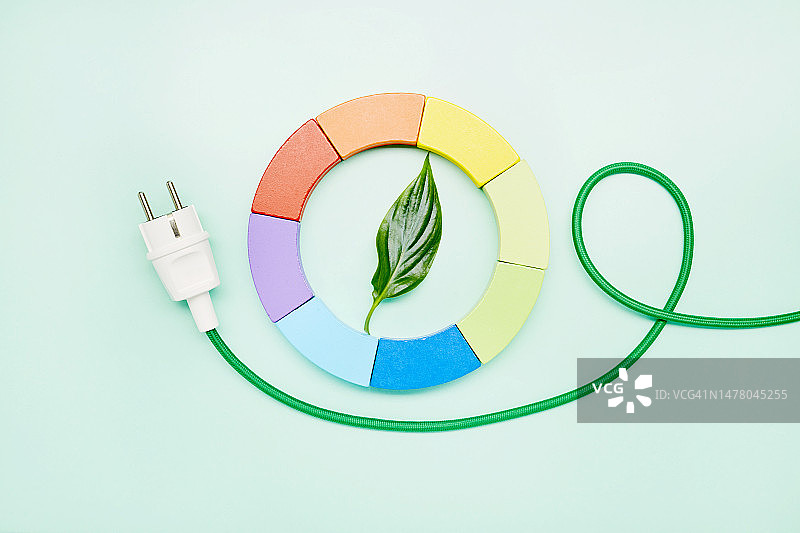 绿色电力电缆与彩色饼图和绿叶在蓝绿色背景，绿色能源图片素材