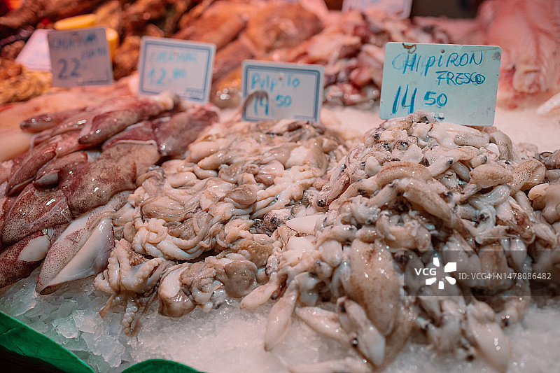 渔民捕获的鱿鱼直接在鱼品拍卖会上出售，然后在市场上出售。在西班牙海鲜店购物图片素材