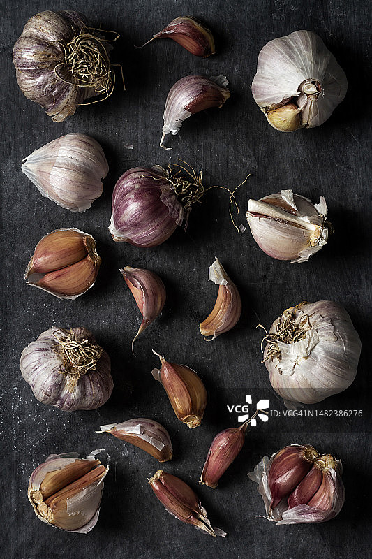新鲜的大蒜鳞茎和丁香组合在黑色背景上图片素材