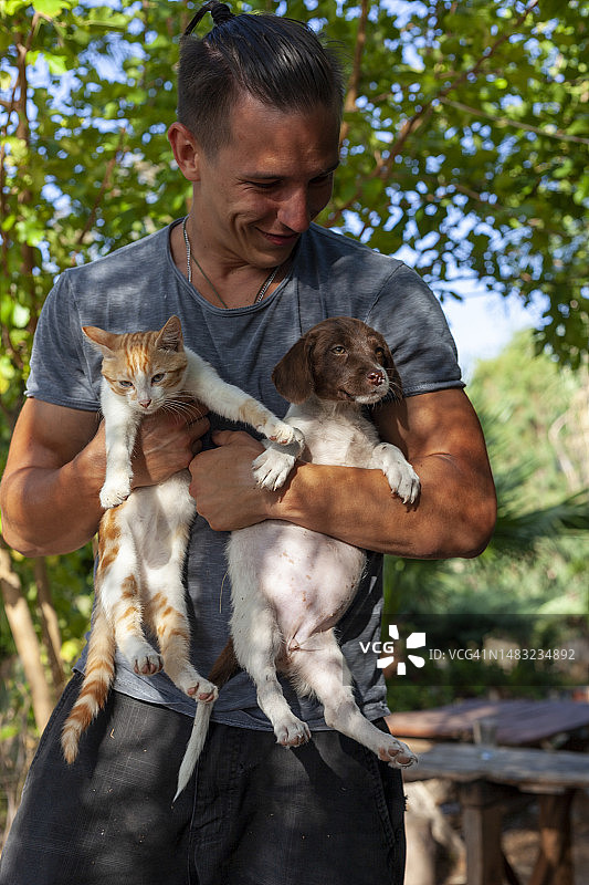 抱着小猫和小狗的男人图片素材