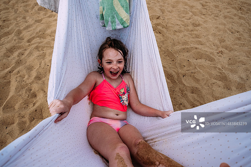 沙滩上小女孩桑迪在吊床上荡秋千图片素材