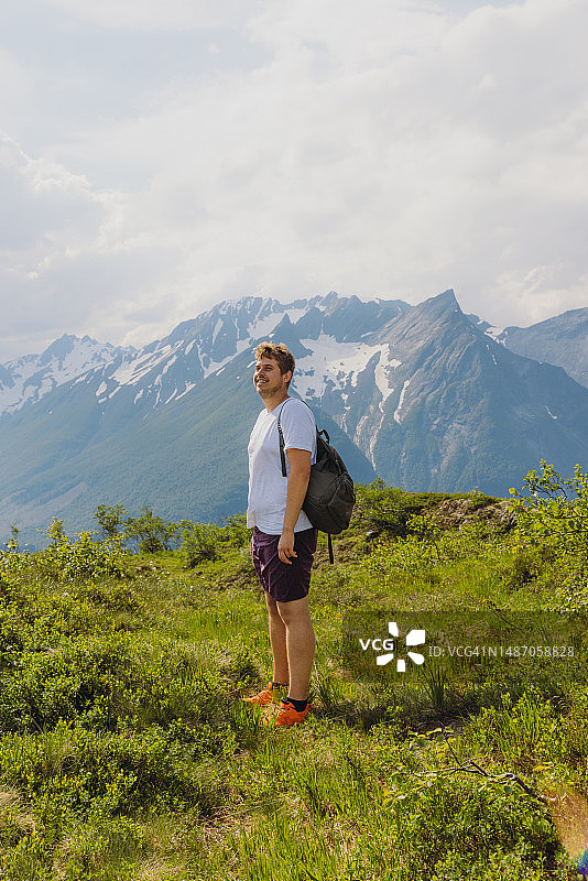 快乐的人考虑徒步旅行在阳光明媚的森莫尔阿尔卑斯山，挪威图片素材