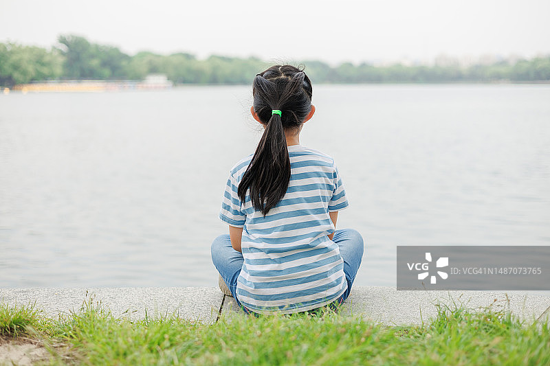 小女孩坐在湖边图片素材