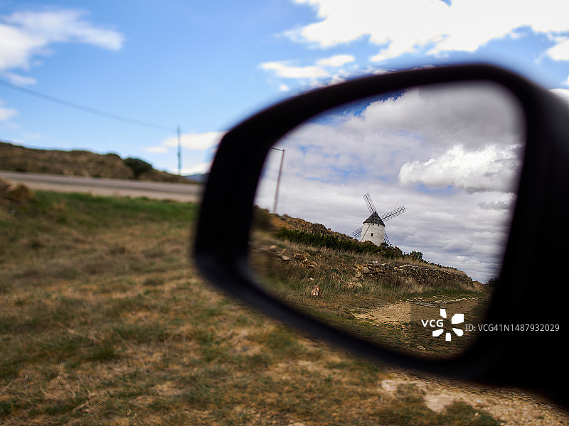 西班牙特鲁埃尔，奥霍斯内格罗斯的传统风车倒映在汽车后视镜上图片素材